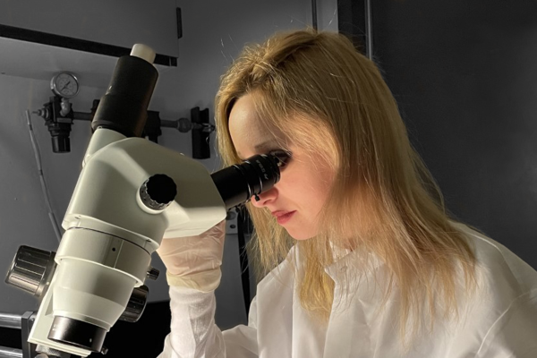 picture of graduate studnet looking through scope